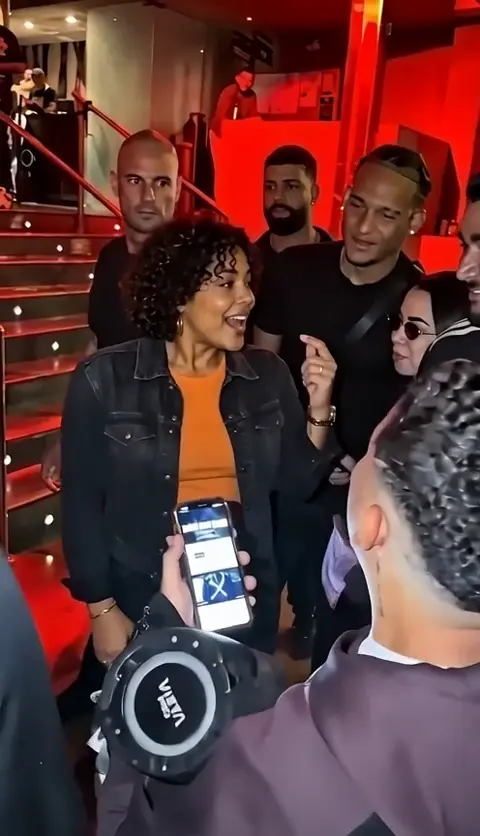 Your outfit, a freestyle and friends filming by the red-lit stairs.